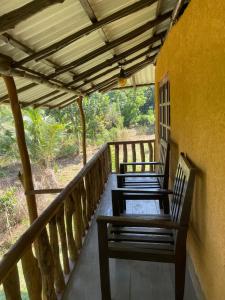 two benches sitting on the porch of a house at Morakanda Estate in Kahaduwa