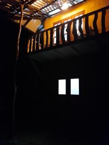 a dark room with a bed with four white windows at Morakanda Estate in Kahaduwa