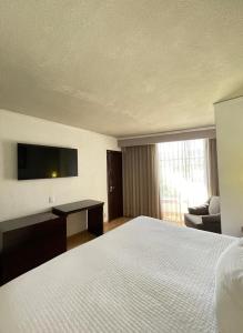 a hotel room with a bed and a flat screen tv at Arroyo Express in Zacatecas