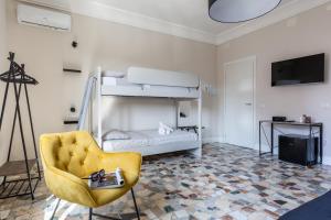 a living room with a yellow chair and a bunk bed at Lorixedda Rooms in Quartu SantʼElena