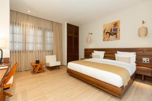 a bedroom with a large bed and a desk at Native Hotels Ouidah in Kika +38 photos