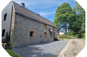 an old stone building with a tree in the background at Gîte 2 pers - La Pommeraie - Le Coin Ardenne in Sainte-Ode