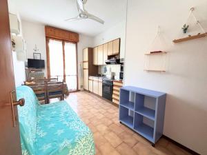 a living room with a blue chair and a kitchen at CV019 - Cervia, bilocale con balcone e posto auto in Milano Marittima +9 photos