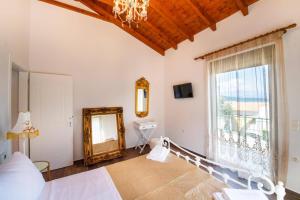 a bedroom with a bed and a mirror and a window at Villa Loulou by Villa Plus in Nikiana +20 photos