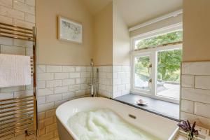 a bath tub in a bathroom with a window at 4 Bed in Oswestry oc-87477 in Llansilin +44 photos