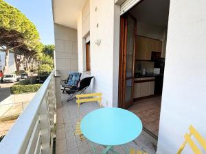 a balcony with a blue table and chairs and a kitchen at CV019 - Cervia, bilocale con balcone e posto auto in Milano Marittima