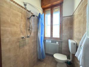 a bathroom with a toilet and a blue shower curtain at CV019 - Cervia, bilocale con balcone e posto auto in Milano Marittima