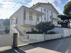 a white house with a white fence in front of it at CV019 - Cervia, bilocale con balcone e posto auto in Milano Marittima