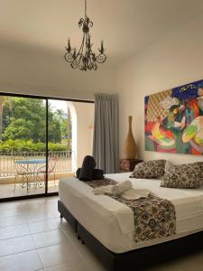 a bedroom with two beds and a large window at Hotel y Spa Santa Fe Colonial in Santa Fe de Antioquia +69 photos