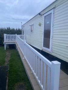 a white railing on a house with a porch at Woodlands Dene - Crimdon Dene Holiday Park - Accessible in Hartlepool
