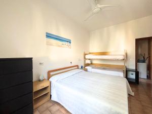 a bedroom with two beds and a dresser and a ceiling at CV019 - Cervia, bilocale con balcone e posto auto in Milano Marittima