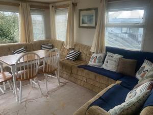 a living room with a couch and a table and chairs at Woodlands Dene - Crimdon Dene Holiday Park - Accessible in Hartlepool +2 photos