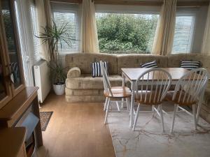 a living room with a table and chairs and a couch at Woodlands Dene - Crimdon Dene Holiday Park - Accessible in Hartlepool