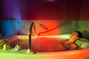 a woman in a bath tub with a faucet at Hotel Bains Sarrailh in Dax +36 photos