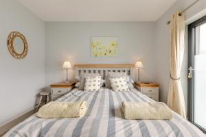 a bedroom with a large bed with two pillows at 3 Bed in Croyde oc-hector in Croyde