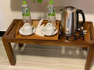 a coffee table with a tea kettle and two water bottles at Happy Rest House Ella in Ella