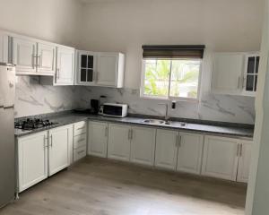 a white kitchen with white cabinets and a window at Apartamento-2B-Zona-Colonial in Santo Domingo