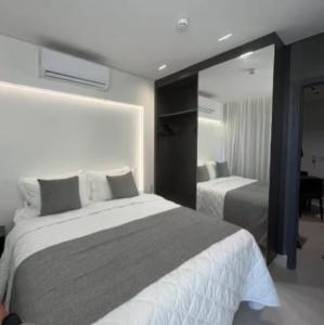 a bedroom with two beds and a large mirror at Gav Muro Alto Resort below average rate in Ipojuca +6 photos
