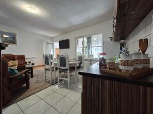 a kitchen and living room with a table and chairs at Apartmani CARDAK in Paša Bunar