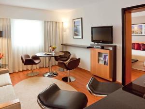 a hotel room with a living area with a table and chairs at Novotel Lima San Isidro in Lima +164 photos