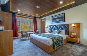 a bedroom with a bed and a desk in a room at Hotel Village Corner in Anantnāg