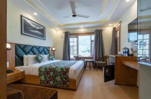 a hotel room with a bed and a desk and a room at Hotel Village Corner in Anantnāg