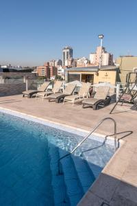 a row of lounge chairs sitting next to a swimming pool at Hotel Everest in Córdoba