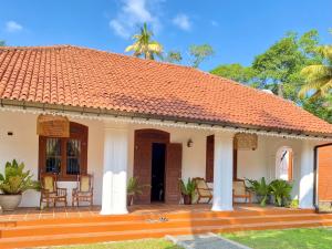 a white house with a red tile roof at MAYA Ahangama in Ahangama