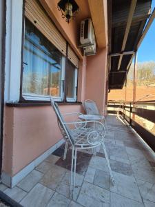 two chairs and a table on the porch of a house at Apartmani CARDAK in Paša Bunar