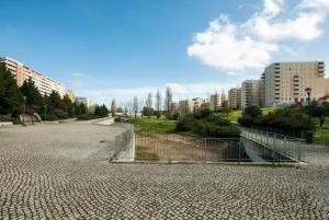 an empty street in a city with tall buildings at Low Cost University Privado in Lisbon +18 photos