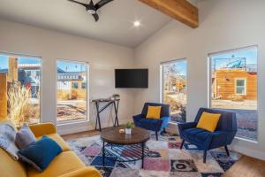 a living room with two blue chairs and a tv at Timber & Tin B 1Bed 1Bath w Pool & Rooftop Deck in Kanab +86 photos