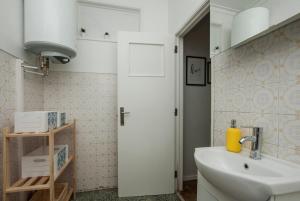 a bathroom with a sink and a white door at Low Cost University Privado in Lisbon