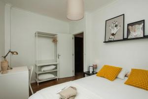 a white bedroom with a bed and a mirror at Low Cost University Privado in Lisbon