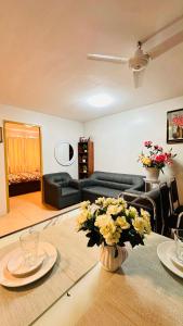 a living room with a table with a vase of flowers at ONE SPATIAL 2Bedrooms Apartment Flat LLD Iloilo City Philippines in Iloilo City