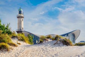 a lighthouse on a beach next to a building at Haus Wilbrand Ferienzimmer 2 in Warnemünde