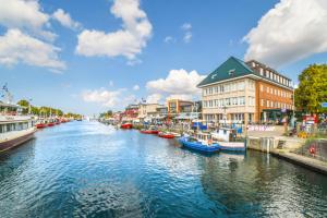 a river with boats in a city with buildings at Haus Wilbrand Ferienzimmer 1 in Warnemünde