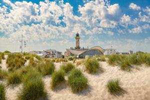 a lighthouse in the middle of a beach with grass at Haus Wilbrand Ferienzimmer 1 in Warnemünde