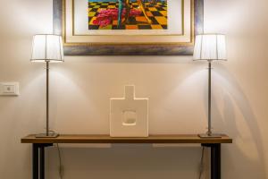 two lamps on a table with a bottle on it at Lorixedda Rooms in Quartu SantʼElena +65 photos