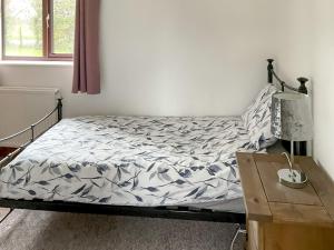 a bedroom with a bed and a lamp and a table at Mistletoe Cottage - Uk50581 in Burnham on Sea