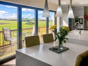 a kitchen with a table and chairs and a balcony at Keppel Gate in Heriot
