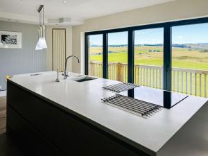a kitchen with a large counter with a large window at Keppel Gate in Heriot