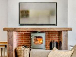 a living room with a brick fireplace with a mirror at Keppel Gate in Heriot