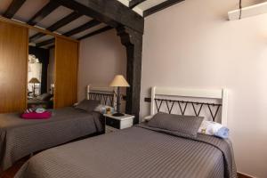 a bedroom with two beds and a mirror at La casona de la alberca in La Alberca