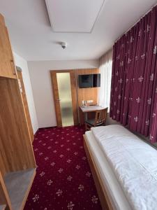 a hotel room with a bed and a desk at Einzelzimmer 9 in Heidenheim