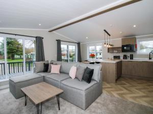 a living room with a couch and a kitchen at Poppy in Leominster
