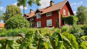 a red house with a garden in front of it at Lägenhet Strömsberg F in Strömsberg