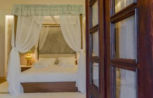 a bedroom with a canopy bed with white curtains at Villa Maria Caetana in Frazão +96 photos
