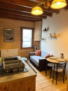 a kitchen and living room with a couch and a table at Moulin de Noallie in Magland