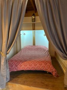 a bed in a room with a curtain at Moulin de Noallie in Magland