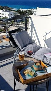 a table with a plate of food and glasses of wine at Idyll Homes THE PENTHOUSE in Avdhelleron